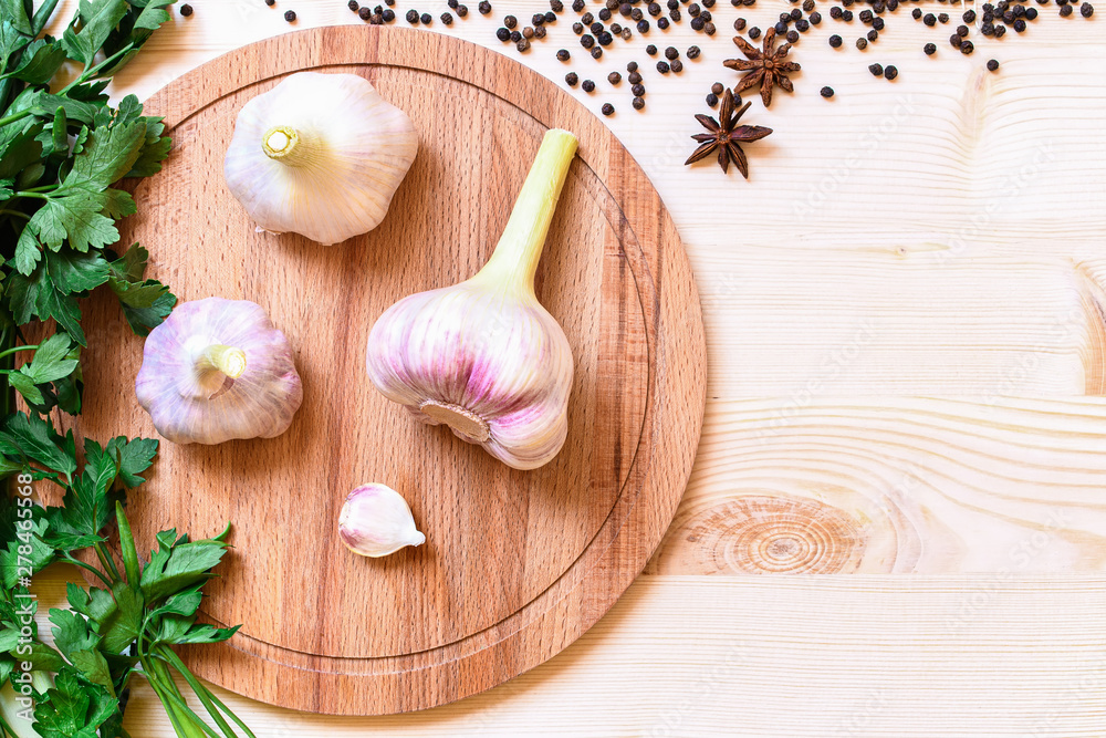 High point view on three pieces fresh garlic on wooden plate High point view on three pieces fresh garlic on wooden plate