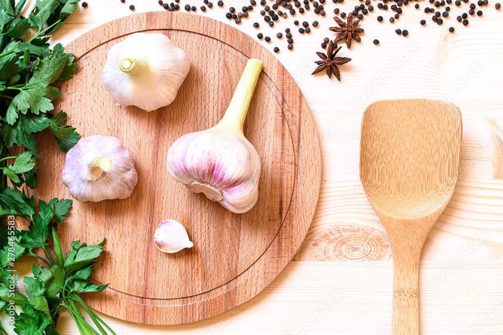 High point view on three pieces fresh garlic on wooden plate High point view on three pieces fresh garlic on wooden plate