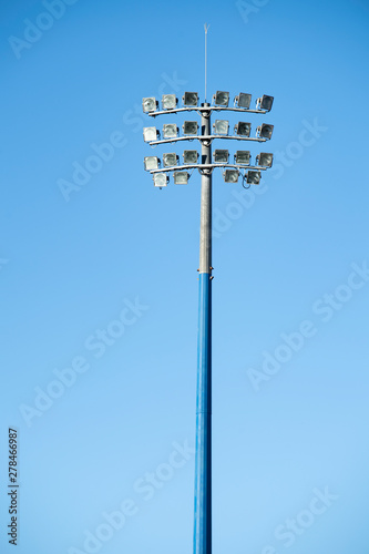 Sports stadium light tower during the day, set against a blue sky.