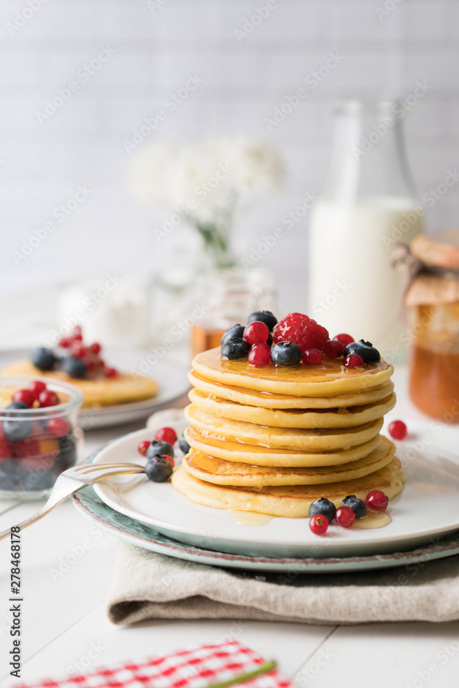 Pancakes mit Beeren am Frühstückstisch Pancakes mit Beeren am Frühstückstisch