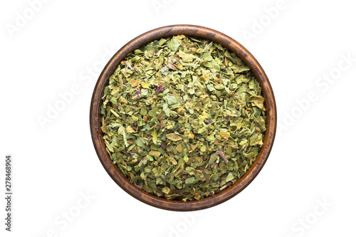 dried marjoram spice in wooden bowl, isolated on white background. Seasoning top view
