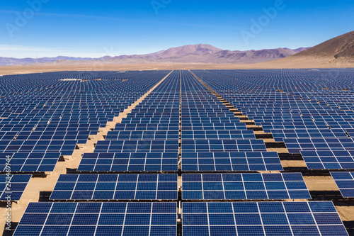 Aerial view of hundreds solar energy modules or panels rows along the dry lands at Atacama Desert, Chile. Huge Photovoltaic PV Plant in the middle of the desert from an aerial drone point of view photo