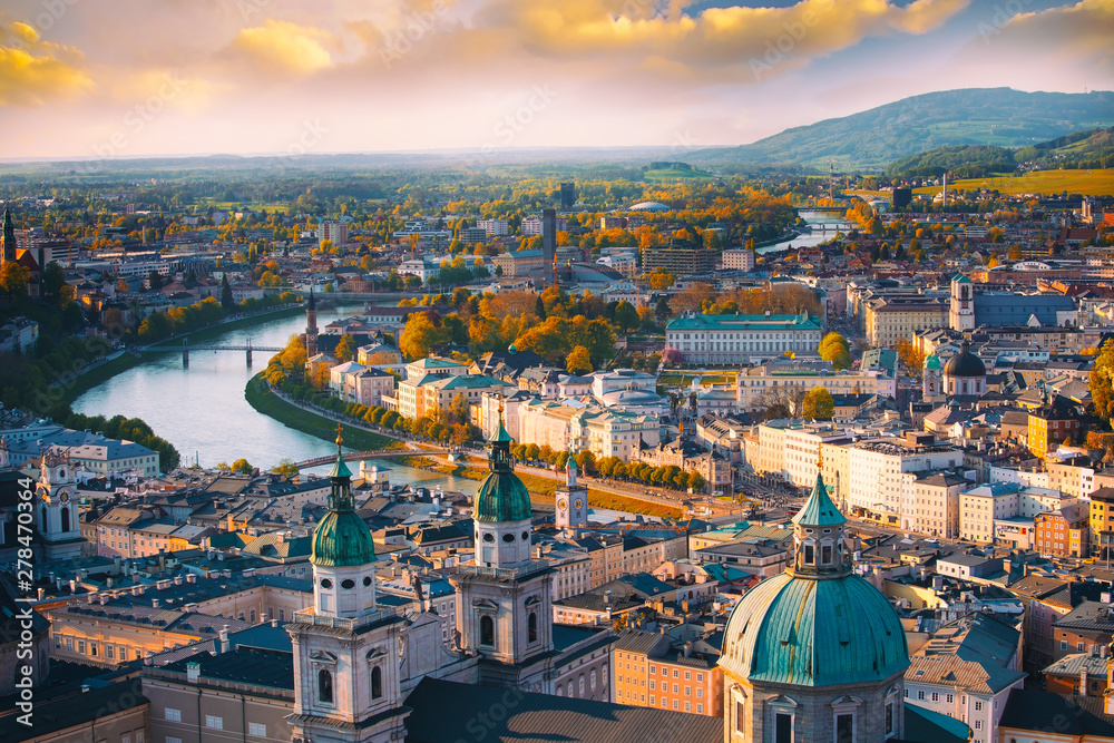 Naklejka premium Piękny panoramiczny widok z lotu ptaka w sezonie jesiennym w historycznym mieście Salzburg z rzeką Salzach w pięknym złotym wieczornym świetle i kolorowej jesieni o zachodzie słońca, Salzburger Land, Austria