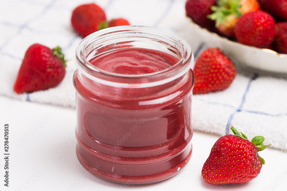 Strawberry jam in a jar on white kitchen towel Strawberry jam in a jar on white kitchen towel