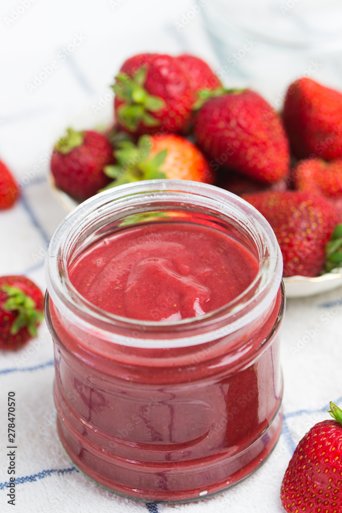 Strawberry jam in a jar on white kitchen towel Strawberry jam in a jar on white kitchen towel