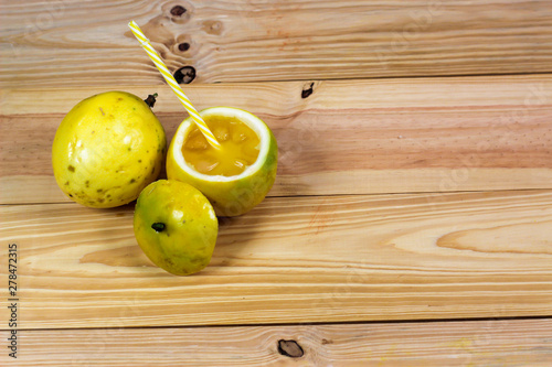 Passion fruits half and juice on the vintage wooden background. Closeup, Select focus.