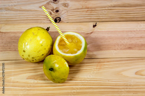 Passion fruits half and juice on the vintage wooden background. Closeup, Select focus.