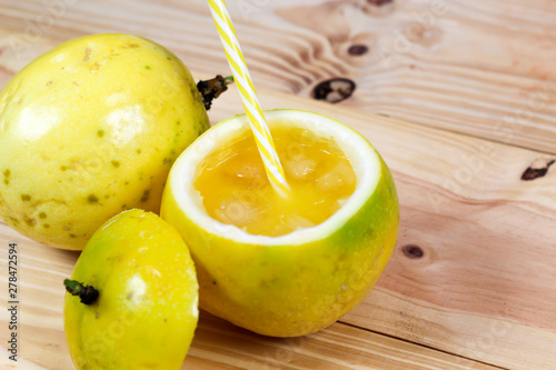Passion fruits half and juice on the vintage wooden background. Closeup, Select focus.