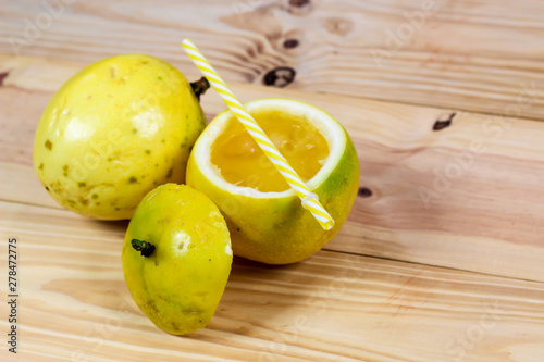 Passion fruits half and juice on the vintage wooden background. Closeup, Select focus.