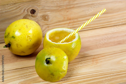 Passion fruits half and juice on the vintage wooden background. Closeup, Select focus.