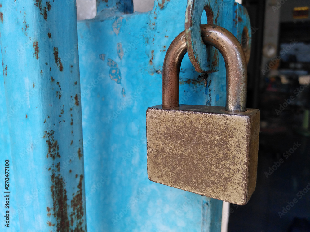 Closeup old master key and rusty lock on blue door. Closeup old master key and rusty lock on blue door.