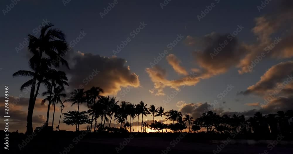 Sunset Timelapse over Kahanamolu Beach, with Palm Trees, Moving Clouds, and People Walking. Sunset Timelapse over Kahanamolu Beach, with Palm Trees, Moving Clouds, and People Walking.