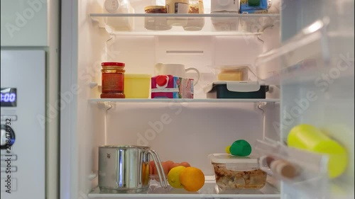Products and food appear and fill fridge indoors