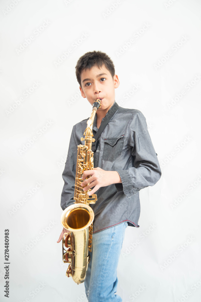 Fototapeta premium Little asian musician boy playing saxophone instrument