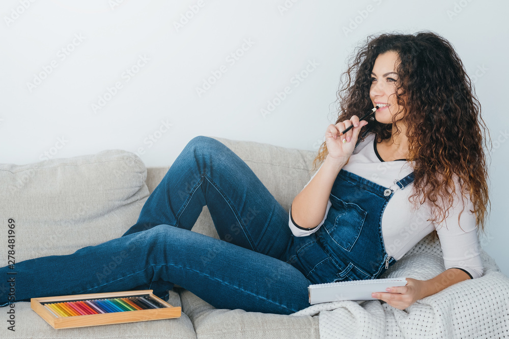 Art hobby and leisure. Inspired lady feeling relaxed on couch at home, thinking on new artwork design. Copy space. Art hobby and leisure. Inspired lady feeling relaxed on couch at home, thinking on new artwork design. Copy space.