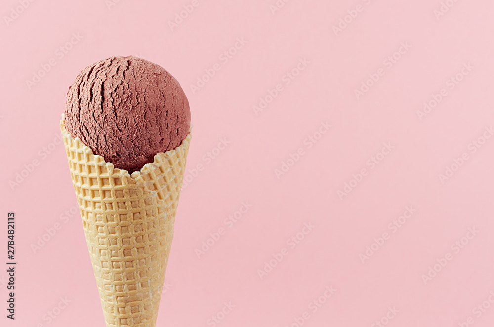 Chocolate brown creamy ice cream in crisp waffle cone on pastel pink background, closeup, details, top, half. Chocolate brown creamy ice cream in crisp waffle cone on pastel pink background, closeup, details, top, half.