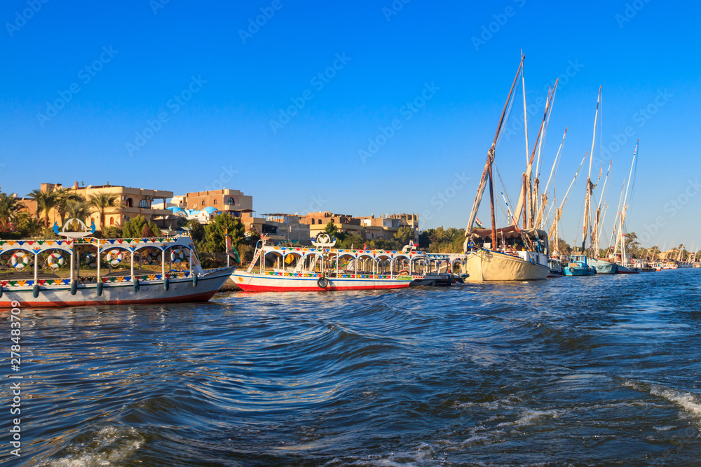 Tourist boats moored near the shore of Nile river in Luxor, Egypt