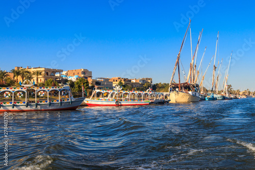 Tourist boats moored near the shore of Nile river in Luxor, Egypt