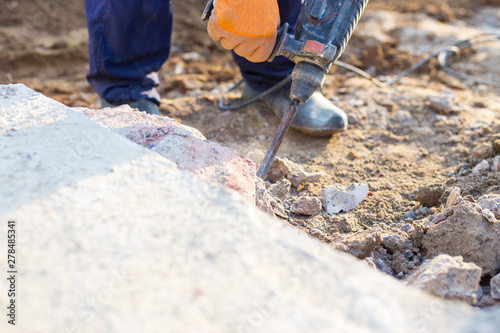 man breaks the concrete with a jackhammer