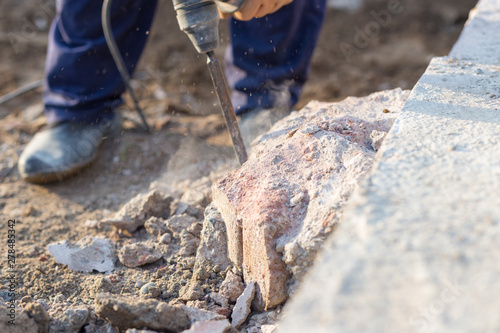 man breaks the concrete with a jackhammer
