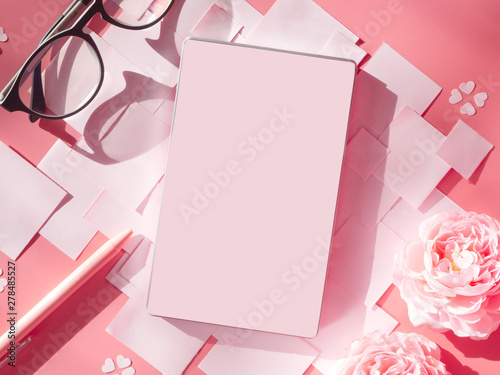 Flat lay style of feminine workspace desk, papers, sheet, notepad, pen and flowers in pink tone. Mockup with copy space for text.