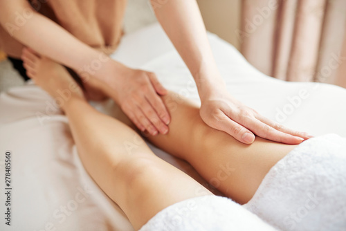 Close-up image of woman getting anti cellulite massage of legs in spa salon