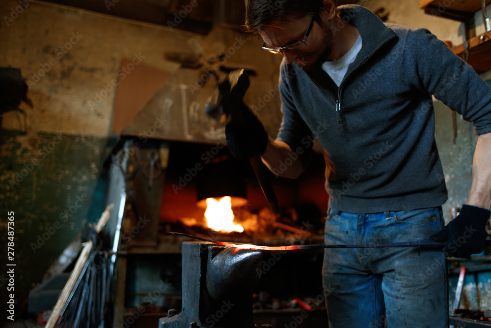 Blacksmith forging red-hot metal with hammer. Blacksmith forging red-hot metal with hammer.