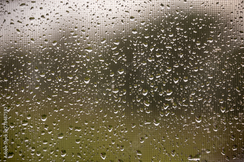 texture of rain drops on dirty window glass over blur and cloudy sunset sky background