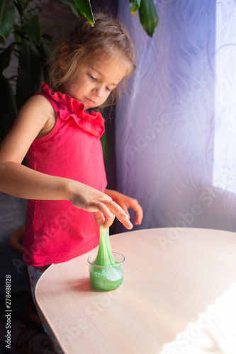 the girl plays with an opposite toy - a green slime. The stretched slime