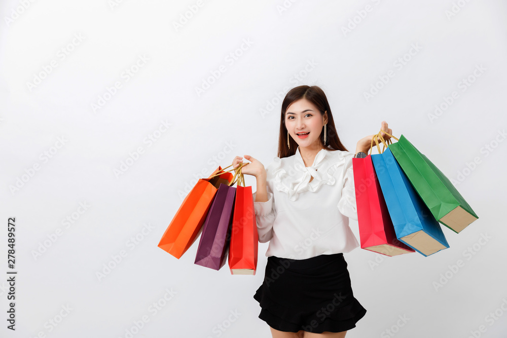 Portrait of beautiful woman holding shopping bags over white background