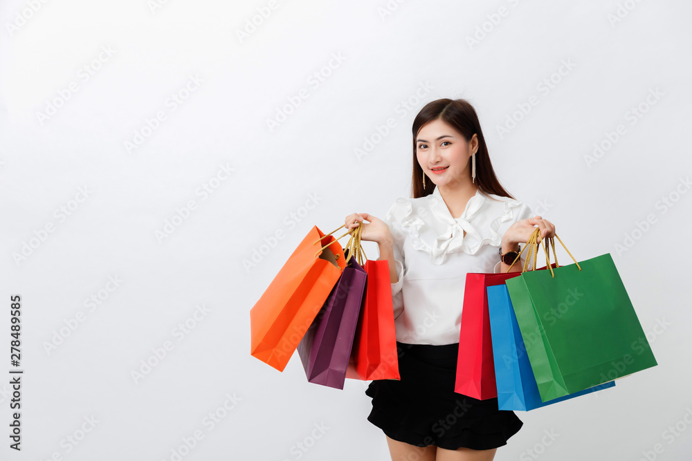 Portrait of beautiful woman holding shopping bags over white background Portrait of beautiful woman holding shopping bags over white background