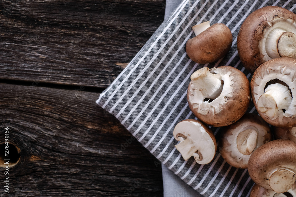 Fototapeta premium Brown mushrooms on old dark wooden background