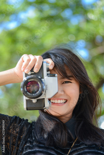 Young asian woman holding a classic camera photo