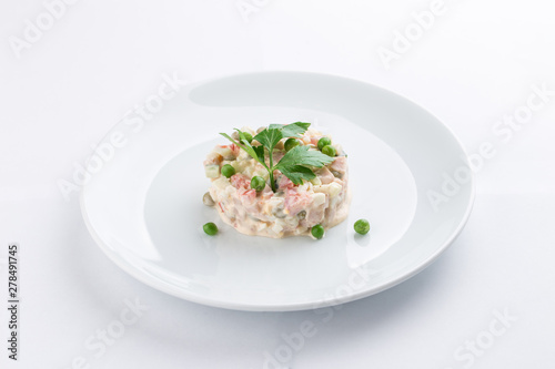Russian traditional salad Olivier with parsley isolated on white background