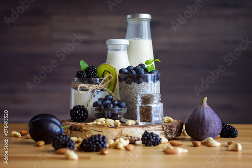 Fototapeta Naklejka Na Ścianę i Meble -  Organic natural breakfast, consists of yogurt with chia, berries, nuts, summer fruits on table. Meal that promotes good digestion and functioning gastrointestinal tract. Healthy food concept.
