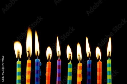 Burning birthday candles on black background