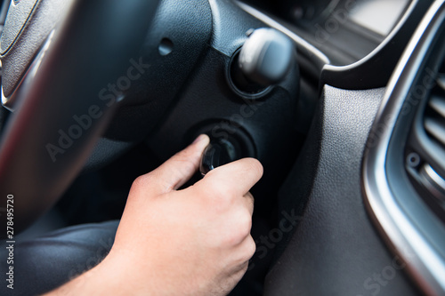 man inserting key in car