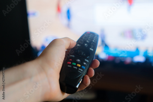 hand holding a tv remote, swithing media chanels screen