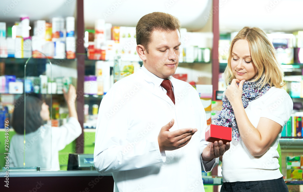 male medical pharmacist or pharmacy worker helping the buyer male medical pharmacist or pharmacy worker helping the buyer