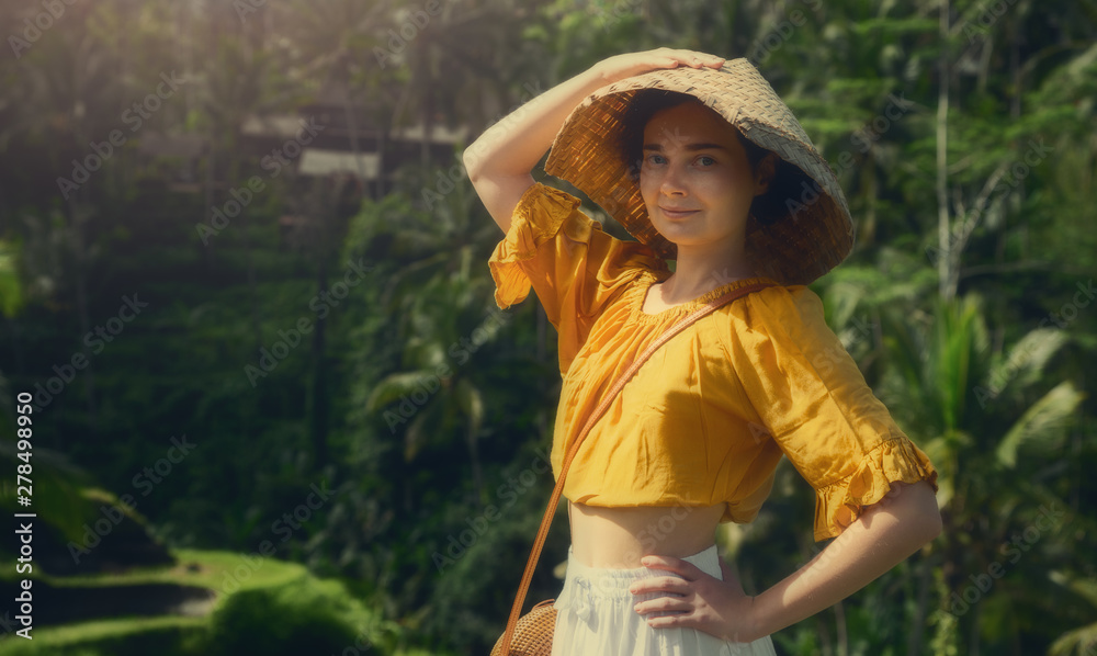 A girl in a white dress on the rice terraces of Tegallalang. Bali trip. Tropical landscape. Travel.