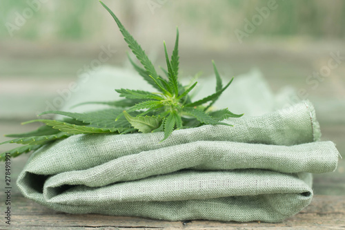textile made of cannabis and green leaves wooden background