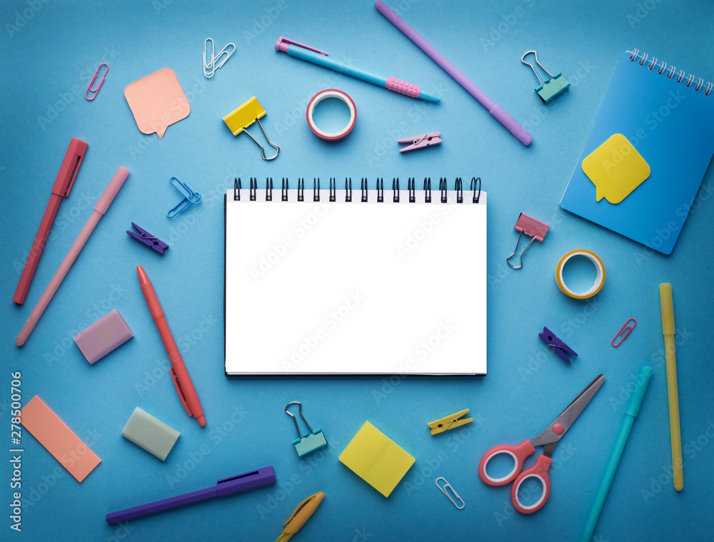 Notepad with white blank space surrounded by office supplies Notepad with white blank space surrounded by office supplies