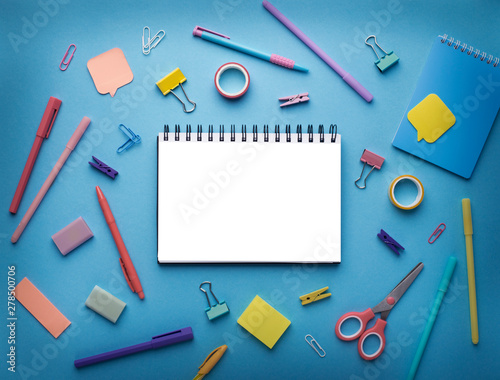 Notepad with white blank space surrounded by office supplies