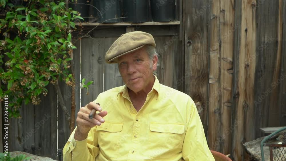Portrait baby boomer melancholy facial expression, thinking of memories and feeling lonely, smoking cigar, slow motion Portrait baby boomer melancholy facial expression, thinking of memories and feeling lonely, smoking cigar, slow motion