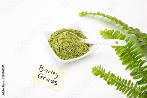 Healthy organic barley grass green powder isolated on white background. Barley grass powder for smoothies as health supplement for added vitamins and minerals to your diet. Young barley for cancer