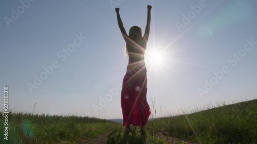 a woman jumping in the air in front of the sun