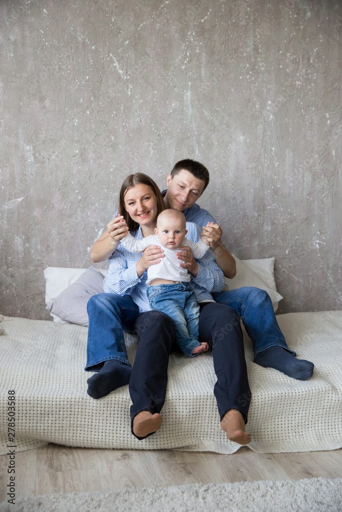 Happy Young Caucasian Family Sitting on Bed Happy Young Caucasian Family Sitting on Bed