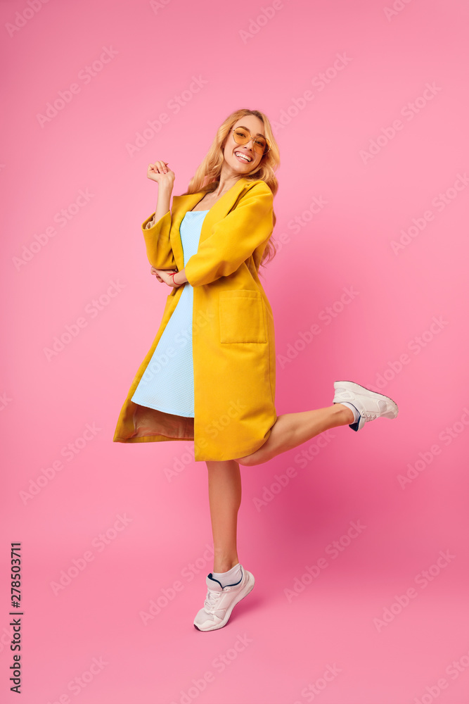 Positive Millennial Girl Jumping and Posing on Pink Background Positive Millennial Girl Jumping and Posing on Pink Background