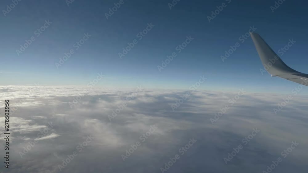 Wing of an airplane flying above the beautiful white clouds.