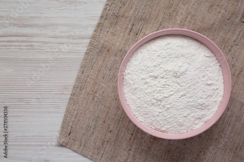 Gluten free rice flour in a pink bowl,  top view. Flat lay, overhead, from above. Copy space.